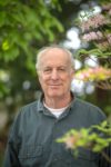 Entomologist and author Doug Tallamy stands by flowering tree